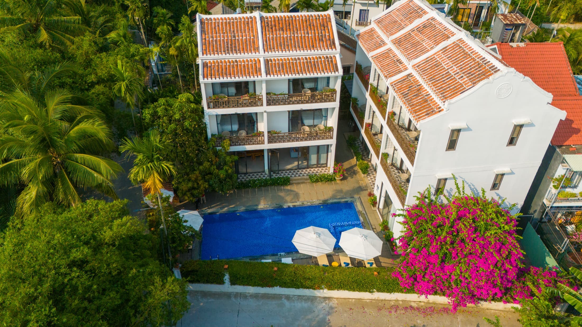 Aerial view of Chiều Hạ Villa with its pool, terracotta roofs and bougainvillea garden