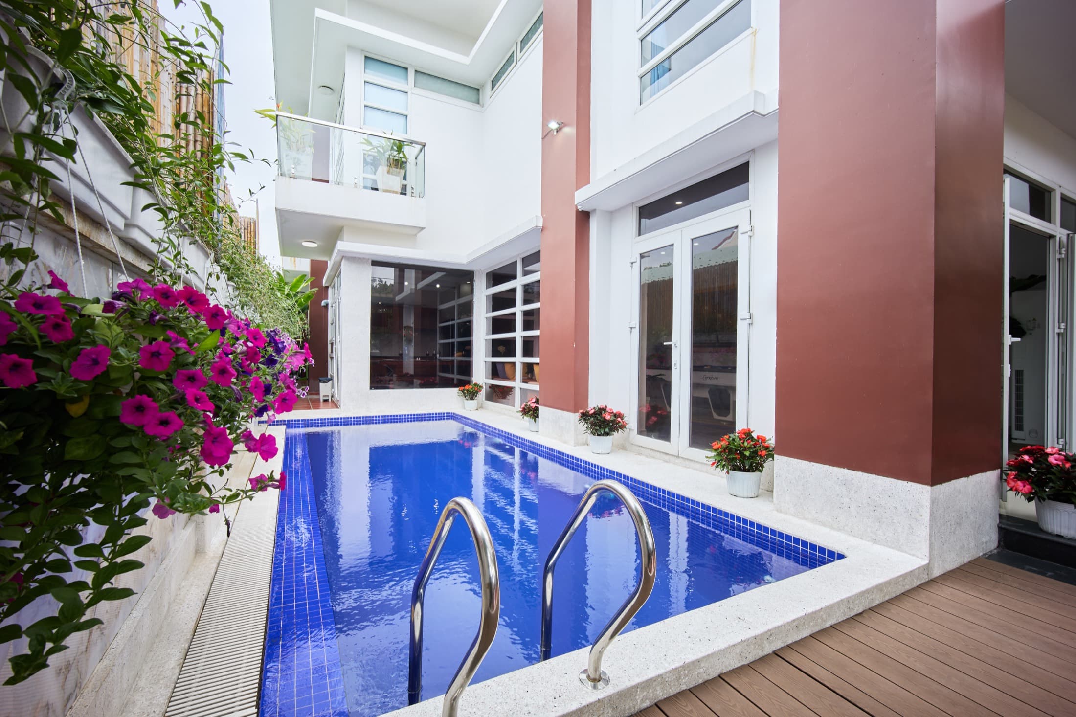 Private pool courtyard framed by bougainvillea at Nelly Villa
